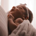 The baby is sleeping in her mother's arms.